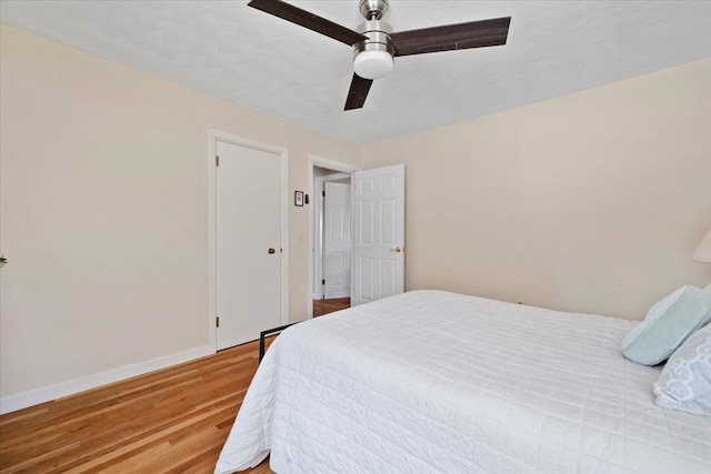 bedroom featuring a ceiling fan, baseboards, and wood finished floors