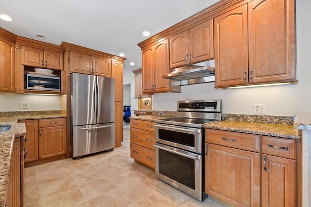 kitchen with appliances with stainless steel finishes, brown cabinetry, under cabinet range hood, and light stone countertops