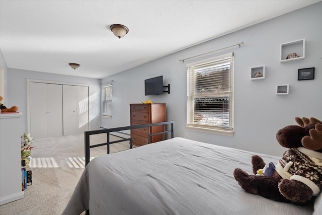 carpeted bedroom with baseboards and a closet