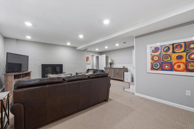 living area featuring light carpet, baseboards, a glass covered fireplace, and recessed lighting