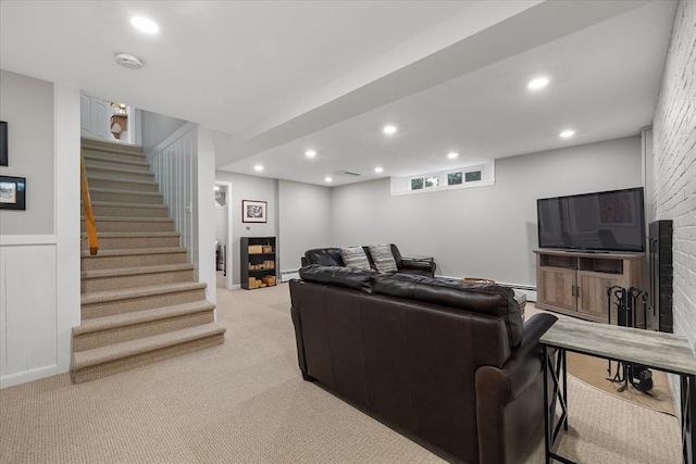 living room featuring a large fireplace, recessed lighting, stairway, and light colored carpet