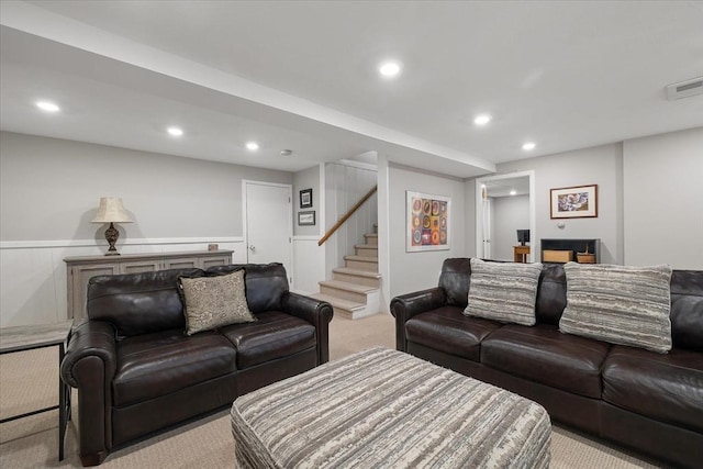 living area featuring wainscoting, recessed lighting, stairway, and light colored carpet