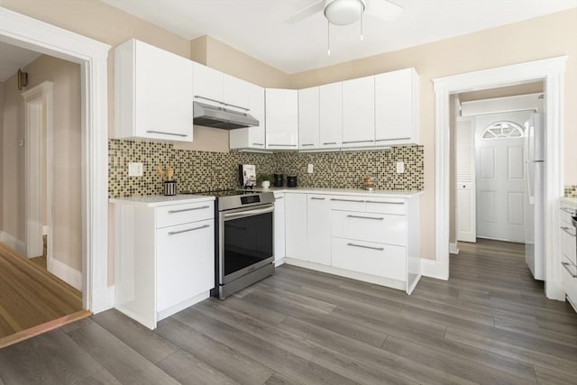 kitchen featuring electric stove, under cabinet range hood, a ceiling fan, light countertops, and dark wood-style flooring