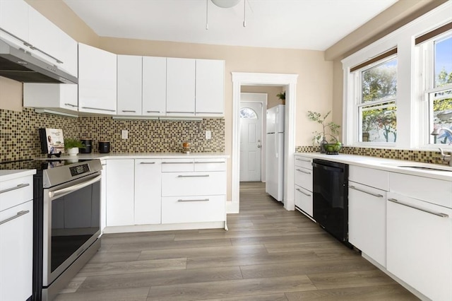 kitchen with stainless steel electric stove, black dishwasher, a sink, freestanding refrigerator, and under cabinet range hood