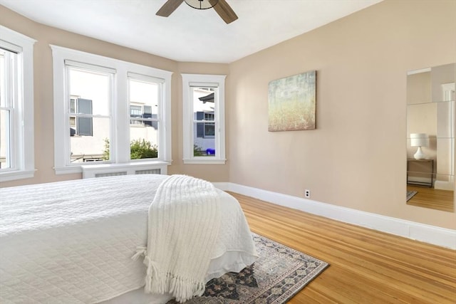 bedroom featuring wood finished floors, baseboards, and ceiling fan