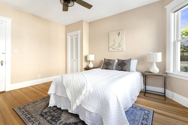 bedroom with baseboards, wood finished floors, and ceiling fan