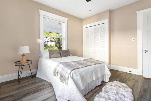 bedroom featuring wood finished floors, baseboards, a closet, and a ceiling fan
