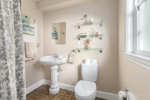 bathroom featuring toilet and baseboards