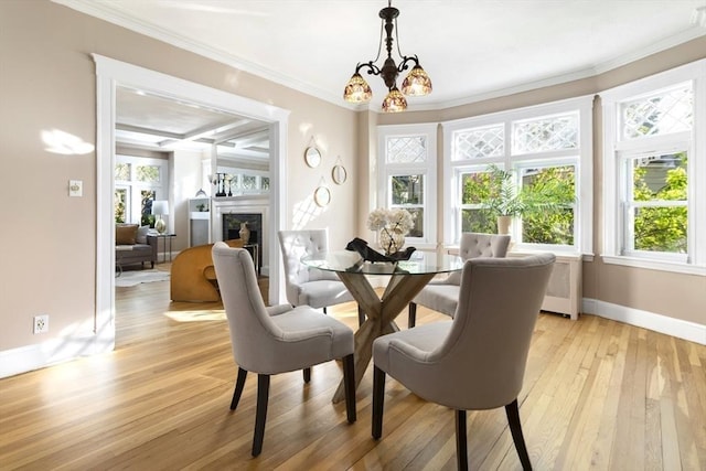 dining room with baseboards, light wood-style floors, plenty of natural light, and ornamental molding