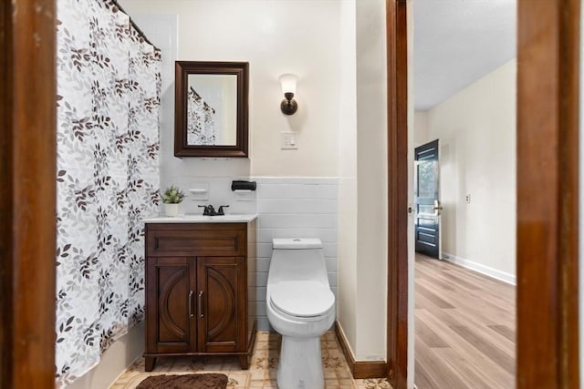 bathroom with a shower with shower curtain, vanity, toilet, and hardwood / wood-style floors