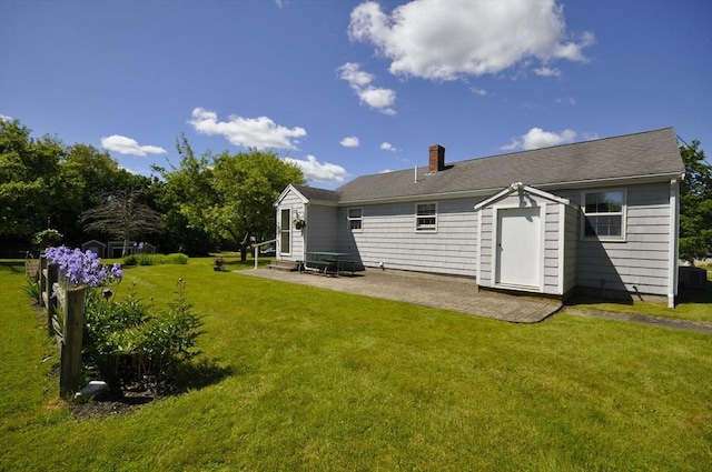 706 Washington St, East Bridgewater, MA 02333 - rear view of house with entry steps, a patio, a chimney, and a yard