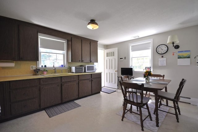 706 Washington St, East Bridgewater, MA 02333 - kitchen with healthy amount of natural light, dark brown cabinets, light countertops, and stainless steel microwave
