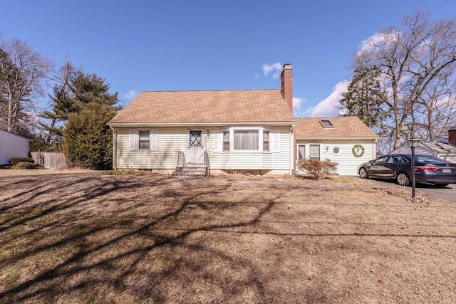 view of front of home with a front lawn, roof with shingles, and a chimney