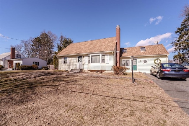 ranch-style house with aphalt driveway and a chimney