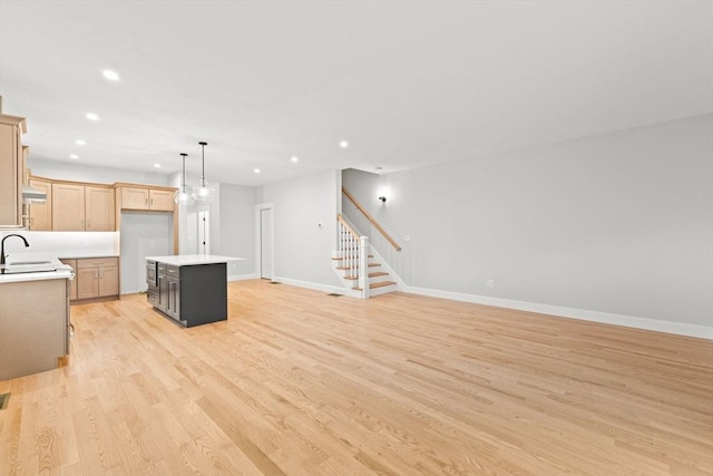27 Leonard St Unit 27, Bridgewater, MA 02324 - kitchen featuring light wood finished floors, a center island, light countertops, recessed lighting, and exhaust hood