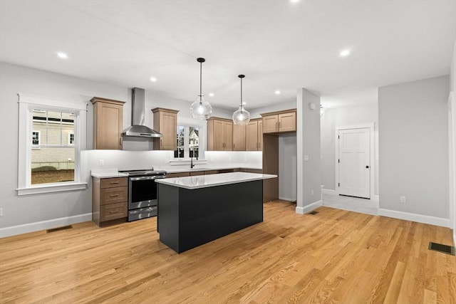 27 Leonard St Unit 27, Bridgewater, MA 02324 - kitchen with stainless steel range with electric cooktop, wall chimney range hood, a kitchen island, light countertops, and light wood-style floors