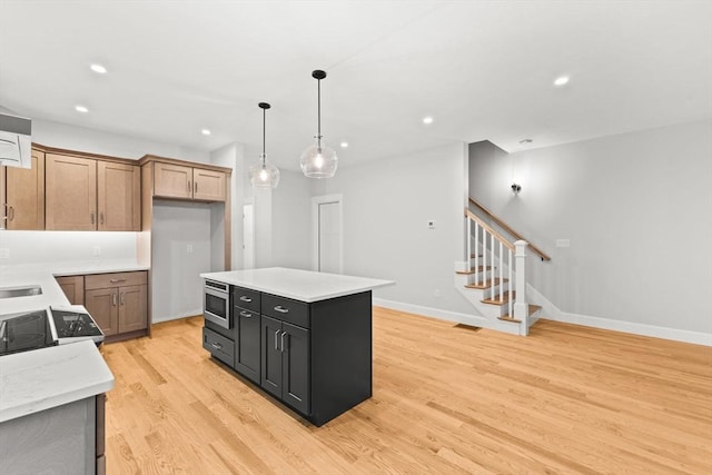 27 Leonard St Unit 27, Bridgewater, MA 02324 - kitchen with light wood-style flooring, light countertops, decorative light fixtures, stainless steel microwave, and stove