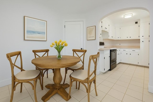 dining area featuring arched walkways, baseboards, visible vents, and light tile patterned flooring