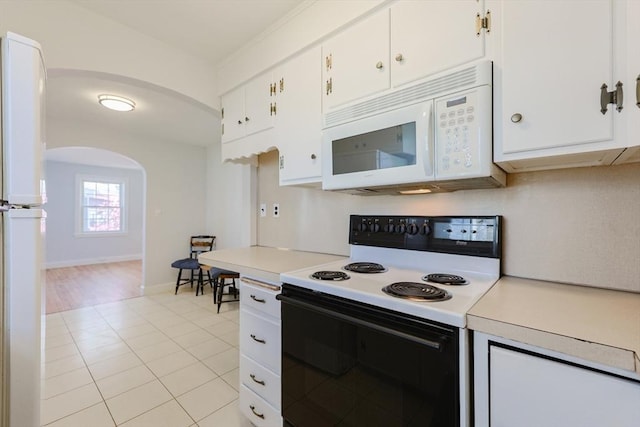 kitchen featuring arched walkways, white cabinets, white appliances, and light countertops