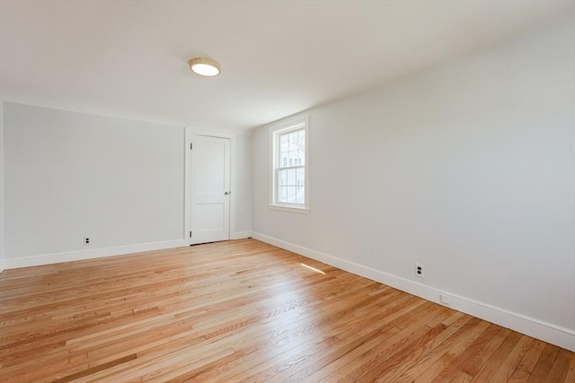 unfurnished room featuring baseboards and light wood-style flooring