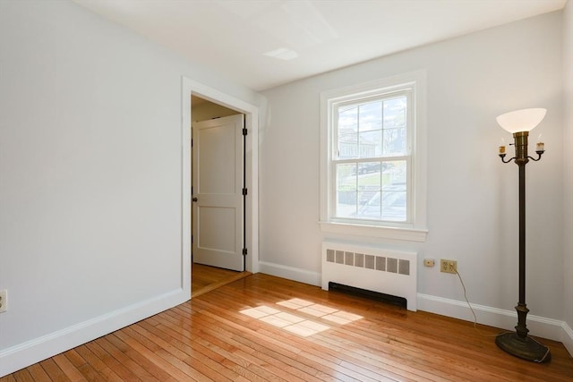 interior space with light wood-style floors, baseboards, and radiator heating unit