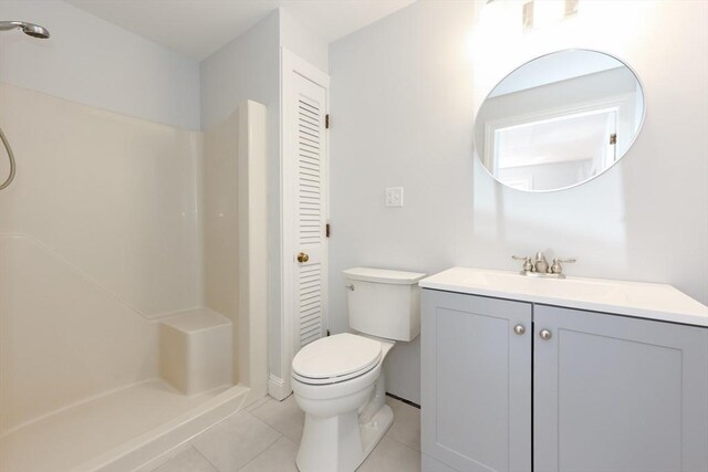 bathroom featuring vanity, a stall shower, tile patterned floors, and toilet