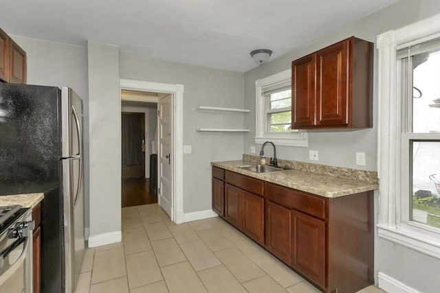 80 Rochelle St, Springfield, MA 01109 - kitchen featuring a sink, stainless steel appliances, light countertops, reddish brown cabinets, and baseboards