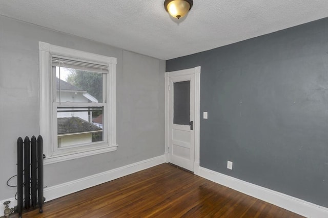 80 Rochelle St, Springfield, MA 01109 - spare room with radiator heating unit, dark wood finished floors, a textured ceiling, and baseboards