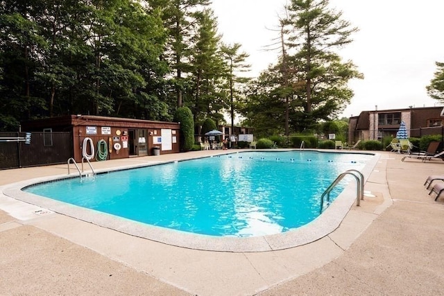 community pool with fence and a patio