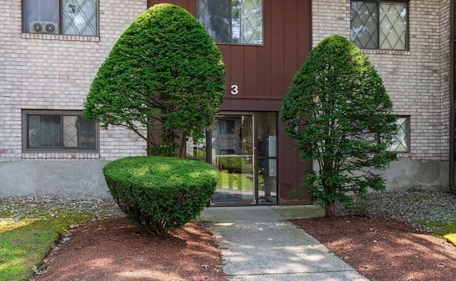 entrance to property featuring brick siding and board and batten siding