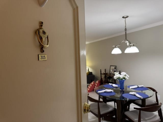 dining space with a chandelier and crown molding