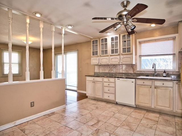 kitchen featuring a sink, a healthy amount of sunlight, decorative backsplash, and white dishwasher