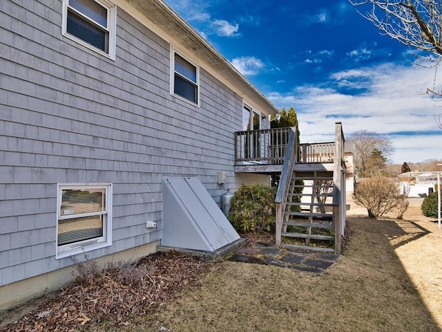 view of side of home featuring stairway and a deck