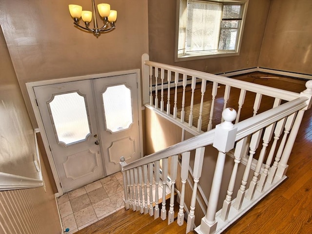 entrance foyer featuring stairs, an inviting chandelier, and wood finished floors