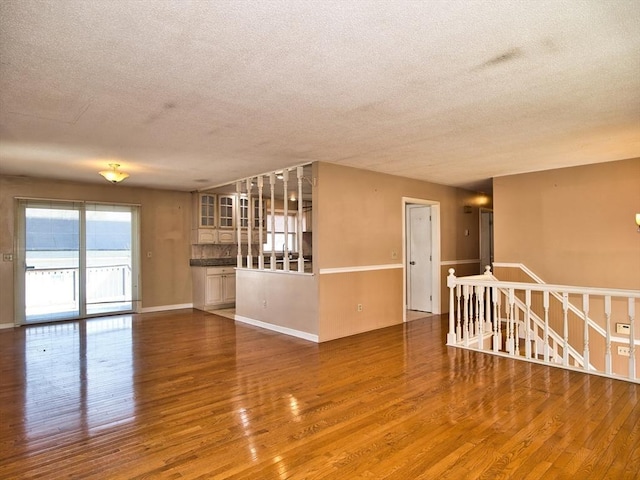 empty room with a textured ceiling and wood finished floors