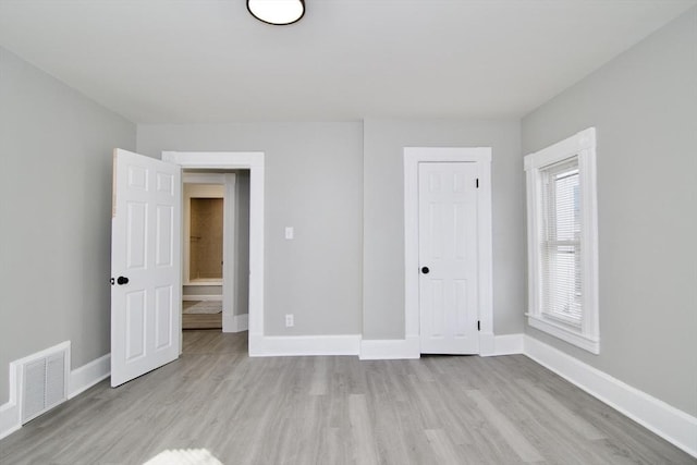 unfurnished bedroom featuring a closet and light hardwood / wood-style floors