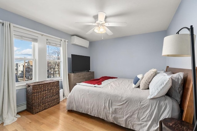 bedroom featuring ceiling fan, light wood-style floors, a baseboard radiator, and a wall mounted AC