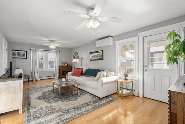 living area with ceiling fan, baseboard heating, an AC wall unit, and light wood-style flooring