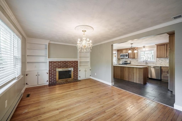 313 Bennett Rd, Hampden, MA 01036 - unfurnished living room featuring baseboard heating, a chandelier, dark wood-style flooring, a sink, and crown molding