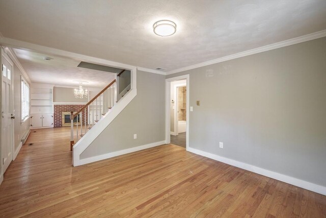 313 Bennett Rd, Hampden, MA 01036 - spare room featuring stairway, baseboards, a chandelier, light wood-type flooring, and crown molding