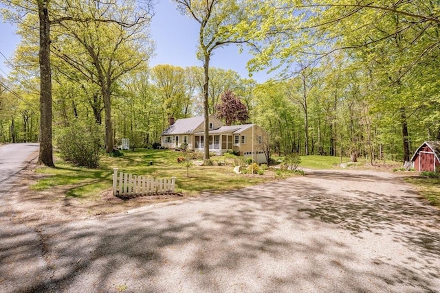 313 Bennett Rd, Hampden, MA 01036 - ranch-style home with driveway, an attached garage, a front yard, a wooded view, and a chimney