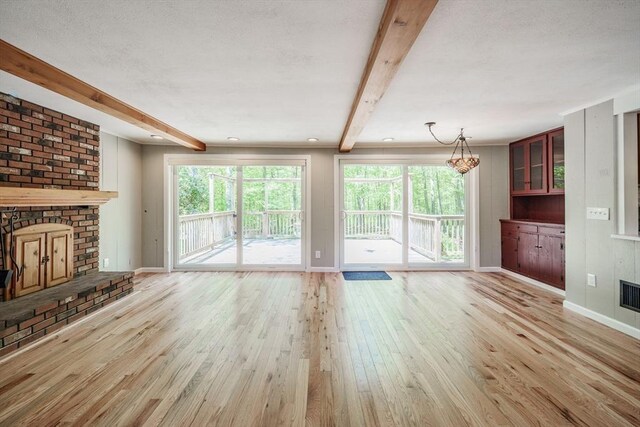 313 Bennett Rd, Hampden, MA 01036 - unfurnished living room with a fireplace, beam ceiling, wood finished floors, healthy amount of natural light, and baseboards