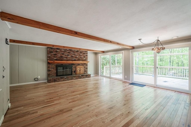 313 Bennett Rd, Hampden, MA 01036 - unfurnished living room with wood finished floors, beam ceiling, a chandelier, a fireplace, and baseboards