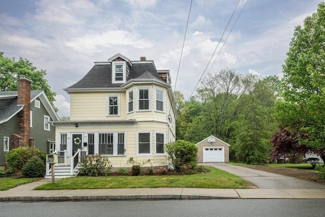 second empire-style home featuring an outdoor structure, driveway, a garage, roof with shingles, and a chimney