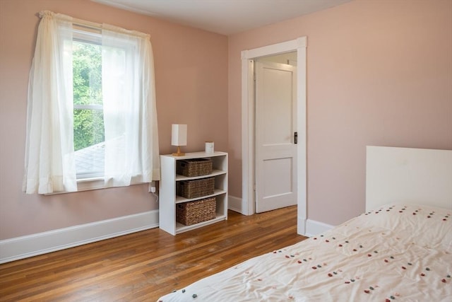 unfurnished bedroom featuring wood finished floors and baseboards