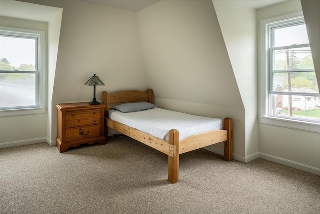 bedroom with light colored carpet and baseboards