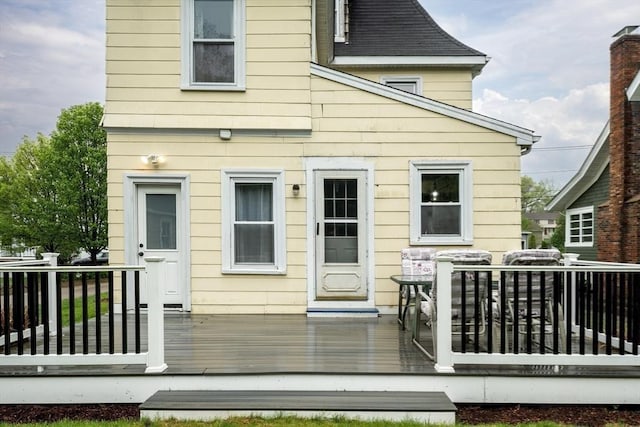rear view of property featuring a wooden deck