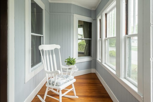 sunroom featuring crown molding, wood finished floors, and baseboards