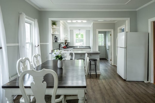 dining area featuring dark wood-style flooring, ornamental molding, and baseboards