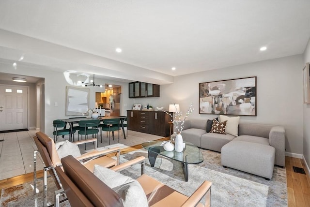 living room with a notable chandelier and light hardwood / wood-style flooring